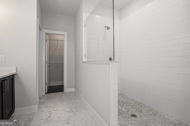 bathroom featuring tiled shower and vanity