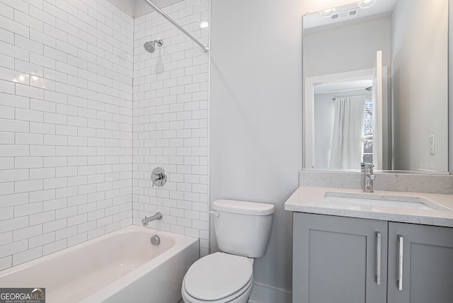 full bathroom with vanity, tiled shower / bath combo, and toilet