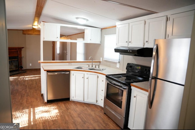 kitchen featuring sink, vaulted ceiling with beams, light hardwood / wood-style floors, white cabinetry, and stainless steel appliances