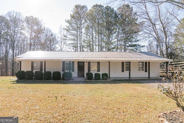 single story home with metal roof, a porch, and a front lawn