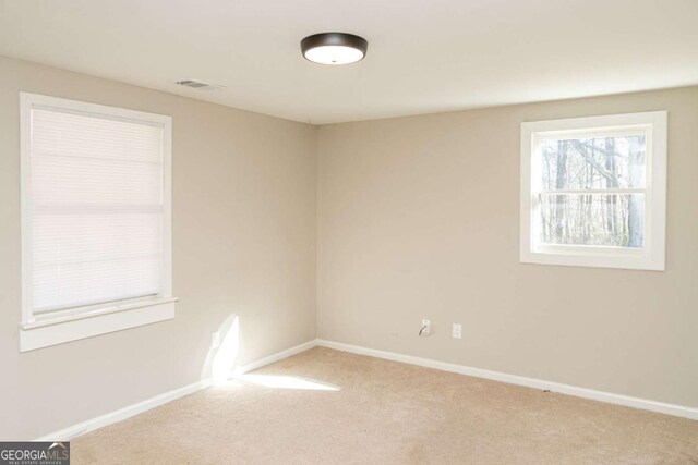 unfurnished room featuring light carpet