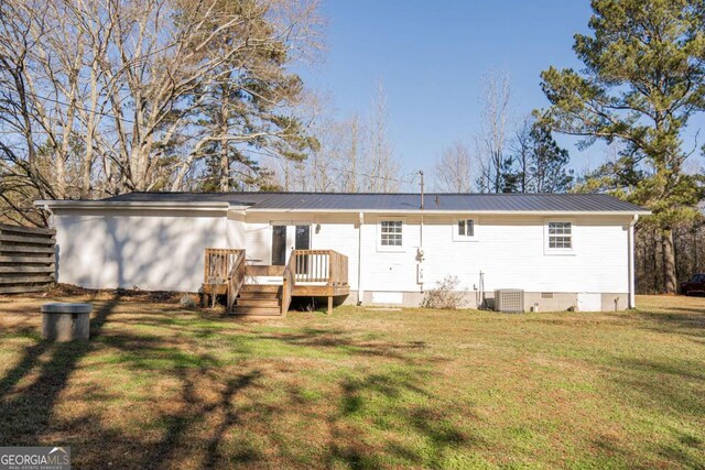 rear view of house with a wooden deck, a yard, and central AC unit