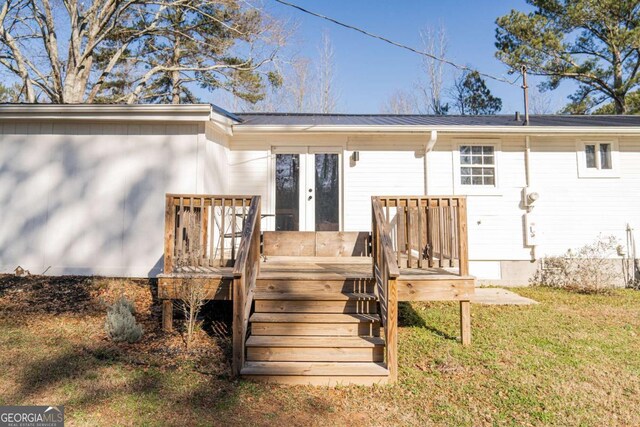 back of house with a deck, a yard, and french doors