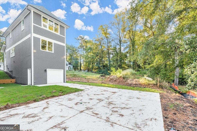 view of side of home featuring a lawn and a garage