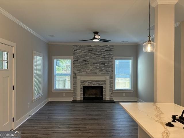 unfurnished living room with a fireplace, dark wood-type flooring, ceiling fan, and crown molding