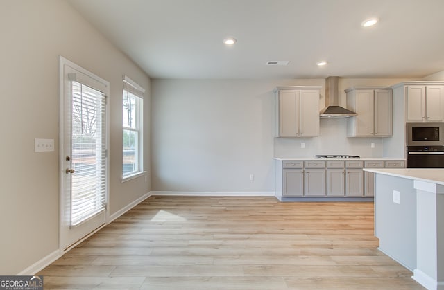 kitchen featuring backsplash, wall chimney exhaust hood, gray cabinets, built in microwave, and gas cooktop