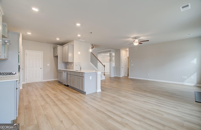 kitchen featuring dishwasher, sink, decorative light fixtures, gray cabinets, and light wood-type flooring