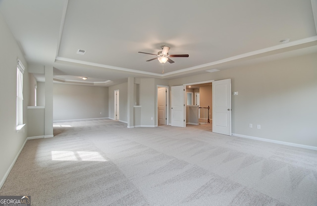 unfurnished room with a tray ceiling, ceiling fan, and light colored carpet