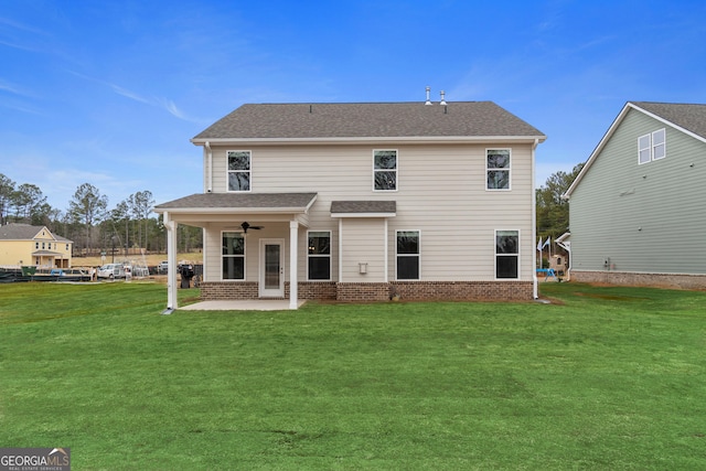 back of property with a lawn, ceiling fan, and a patio