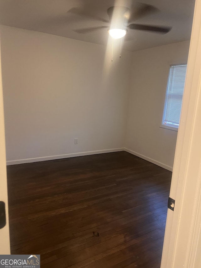 spare room featuring ceiling fan and dark hardwood / wood-style floors