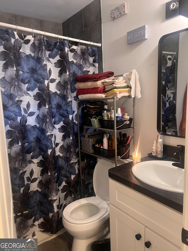 bathroom featuring toilet, vanity, and a shower with curtain