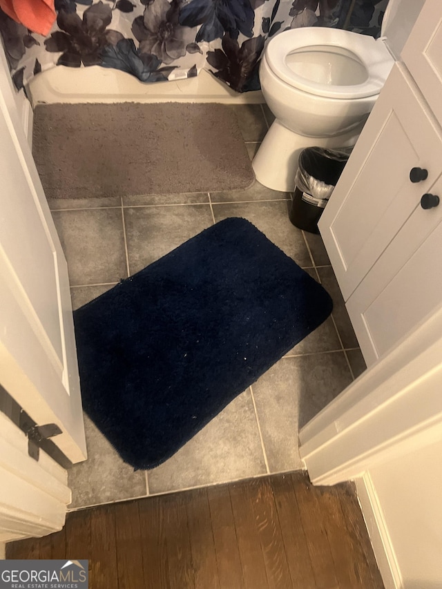 bathroom with hardwood / wood-style flooring and toilet