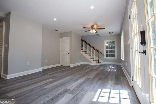 interior space with a wealth of natural light, ceiling fan, and dark hardwood / wood-style flooring