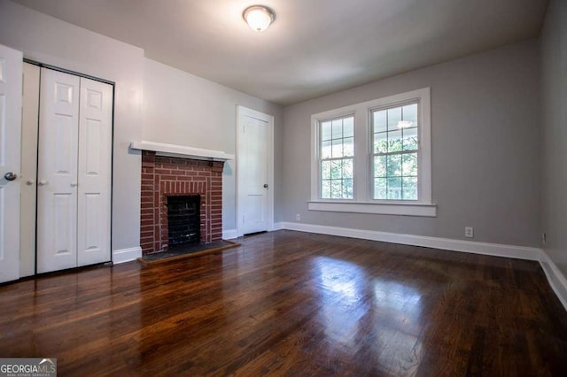 unfurnished living room with a fireplace and dark wood-type flooring
