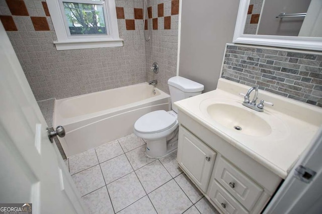 full bathroom featuring backsplash, tile patterned floors, vanity, tiled shower / bath combo, and toilet