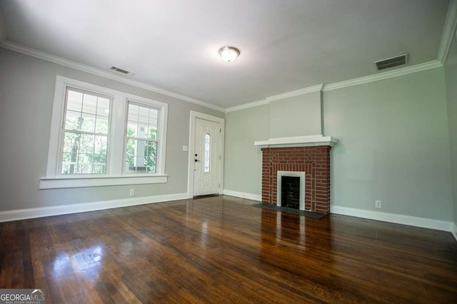 unfurnished living room featuring dark wood-type flooring, ornamental molding, and a brick fireplace