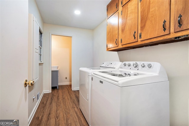 laundry area with dark wood-style flooring, independent washer and dryer, cabinet space, and baseboards