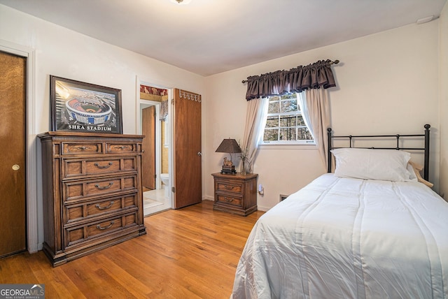 bedroom featuring light wood finished floors and baseboards