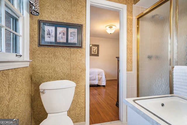 ensuite bathroom with toilet, ensuite bath, and wallpapered walls