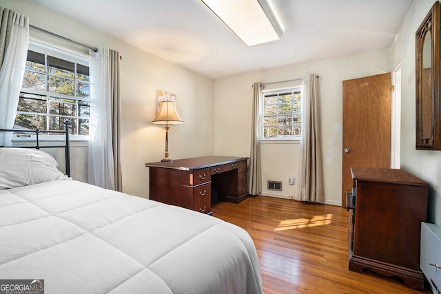 bedroom featuring visible vents and wood finished floors