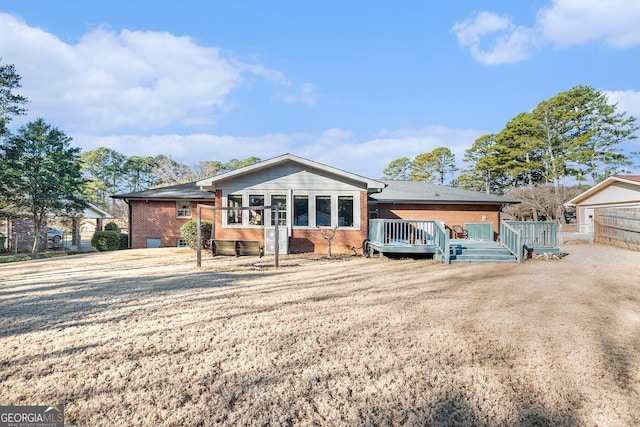 back of property with a wooden deck and brick siding