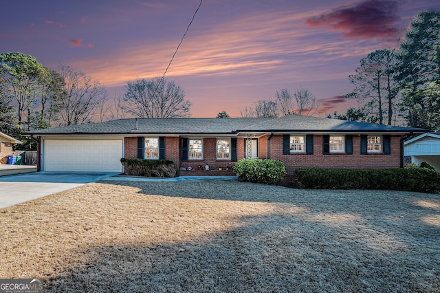 ranch-style home featuring driveway, an attached garage, and brick siding