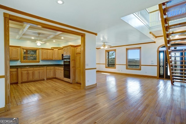 kitchen with coffered ceiling, beamed ceiling, double oven, light wood-type flooring, and ornamental molding