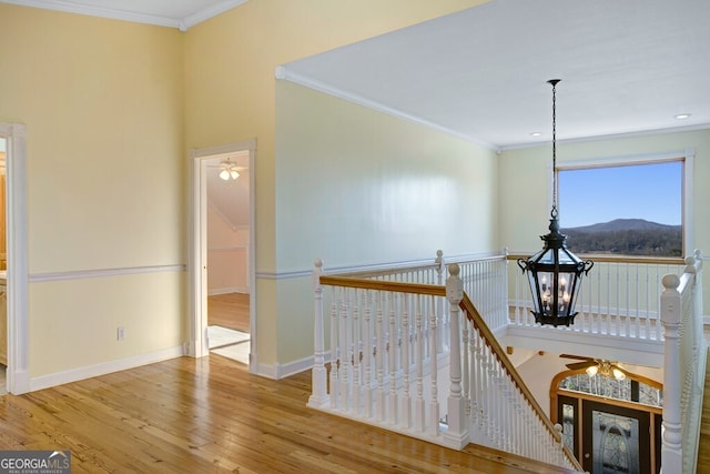 hallway featuring hardwood / wood-style floors, a mountain view, ornamental molding, and an inviting chandelier