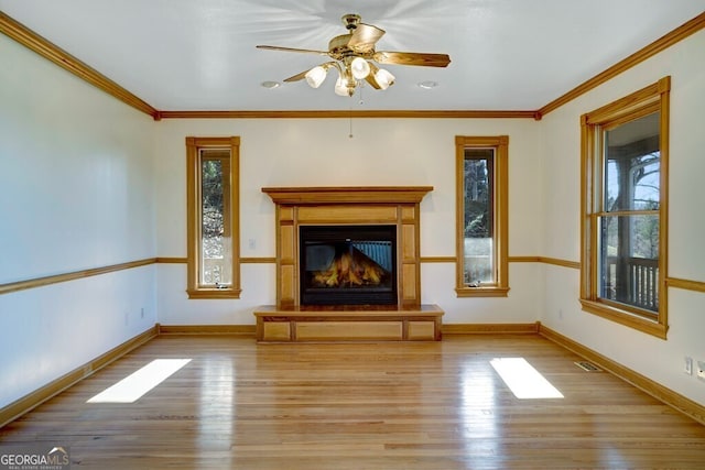 unfurnished living room featuring ceiling fan, light hardwood / wood-style floors, and ornamental molding