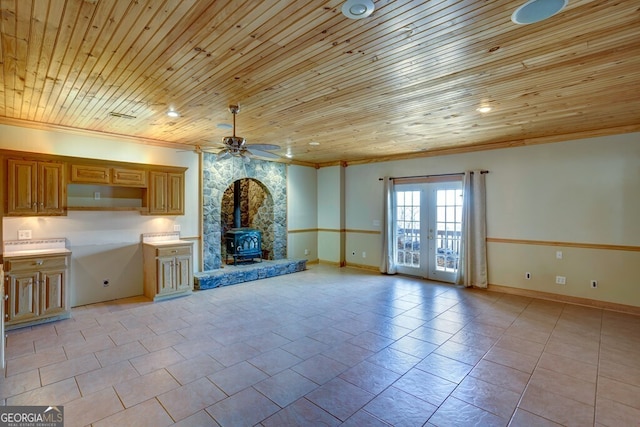 unfurnished living room with french doors, a wood stove, ceiling fan, and wooden ceiling