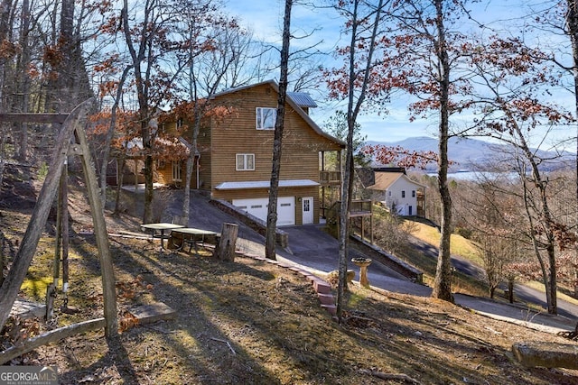 back of house with a mountain view and a garage