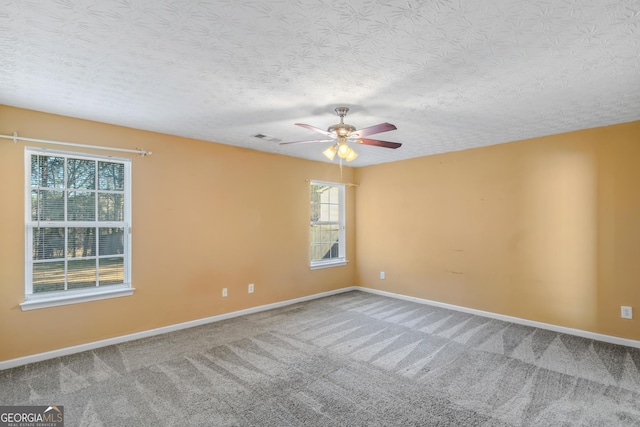 carpeted empty room featuring a textured ceiling and ceiling fan