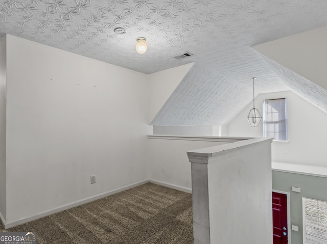 bonus room with lofted ceiling, carpet floors, and a textured ceiling