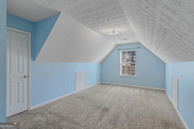 bonus room featuring a textured ceiling, carpet floors, and vaulted ceiling