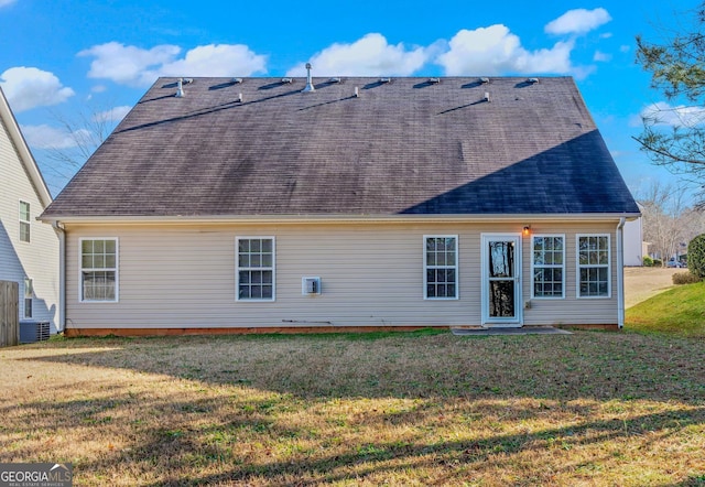 rear view of property with a yard and central air condition unit