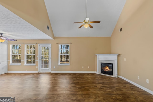 unfurnished living room featuring ceiling fan, dark wood-type flooring, and high vaulted ceiling