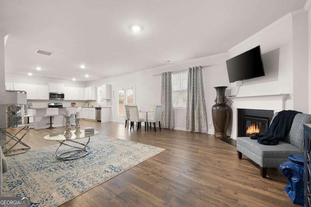 living room with dark hardwood / wood-style floors and crown molding