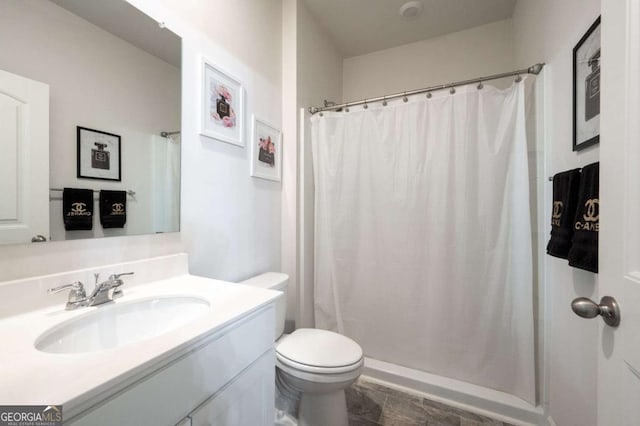 bathroom with walk in shower, vanity, and toilet