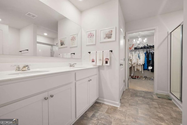 bathroom featuring vanity, a shower with door, and an inviting chandelier