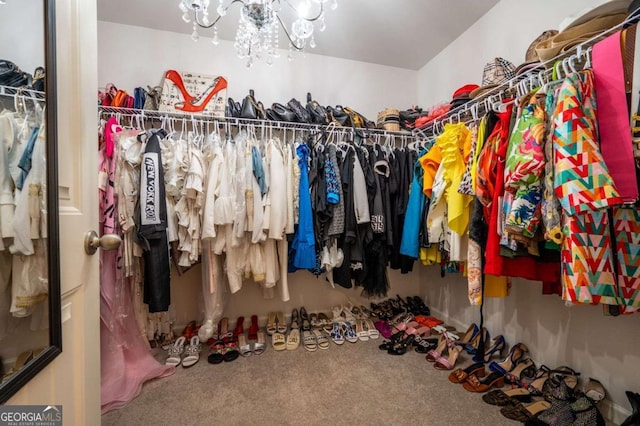 walk in closet featuring carpet floors and a chandelier