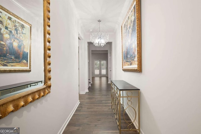 hallway featuring dark hardwood / wood-style flooring and an inviting chandelier