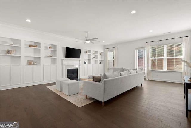 living room with ceiling fan, dark hardwood / wood-style floors, built in features, and ornamental molding