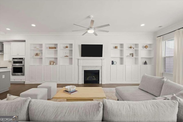 living room with built in shelves, a premium fireplace, dark hardwood / wood-style flooring, and ceiling fan