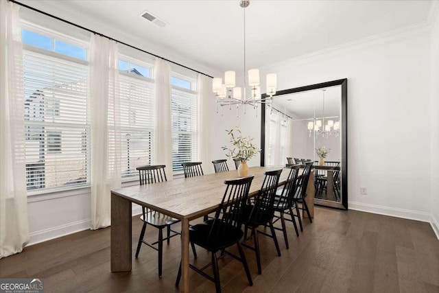 dining room featuring dark hardwood / wood-style flooring, crown molding, plenty of natural light, and a chandelier