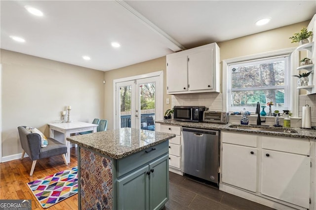 kitchen featuring a kitchen island, dishwasher, sink, white cabinets, and backsplash