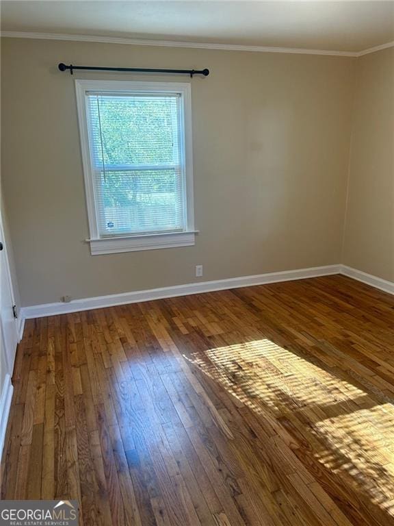 spare room with dark wood-type flooring and ornamental molding