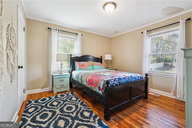 bedroom with dark hardwood / wood-style flooring and ornamental molding