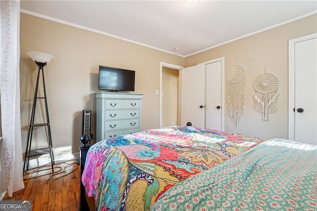 bedroom with crown molding and hardwood / wood-style flooring