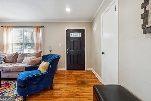 foyer entrance featuring hardwood / wood-style floors and crown molding