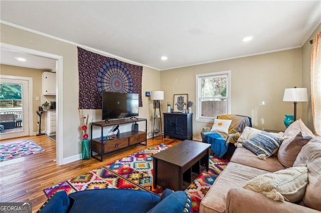 living room with ornamental molding and light hardwood / wood-style floors